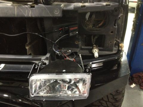 1995 Ford Bronco - A headlight assembly with visible wiring and a ballast is shown, disconnected from the vehicle.