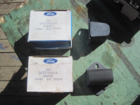 1993 Ford Bronco - Two boxes and two loose Ford bumper parts are displayed on a wooden surface.