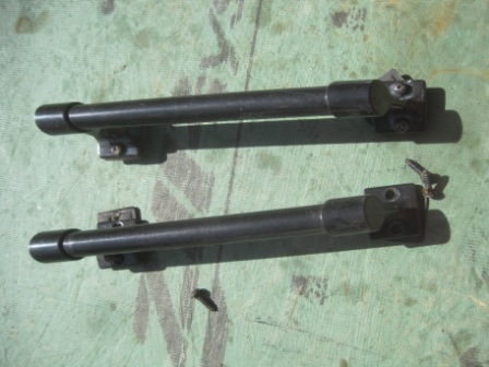 1993 Ford Bronco - Two black metal parts with clips are shown against a green background.