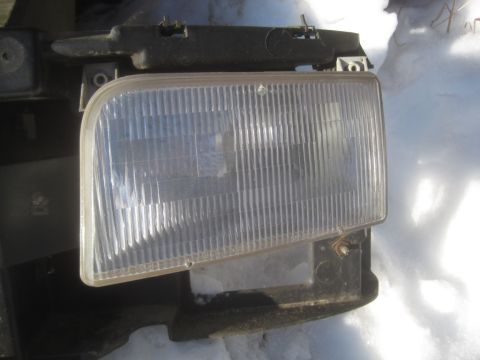 1993 Ford Bronco - This is a headlight assembly with a clear ribbed lens, likely for a vehicle part sale.