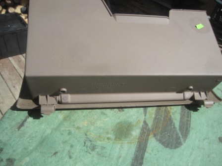 1993 Ford Bronco - This tan dashboard trim piece is shown from the front, with visible mounting clips and some faint text molded into the plastic.