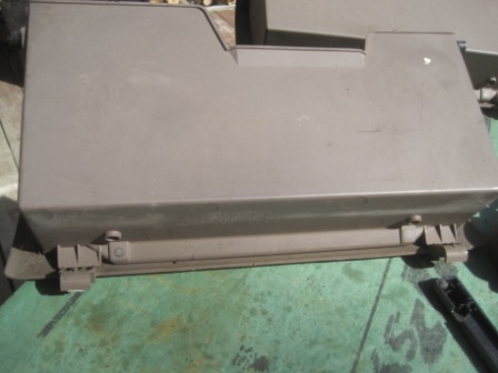 1993 Ford Bronco - This gray plastic dashboard trim piece features visible hinges and latch mechanisms, likely for a vehicle's interior compartment.