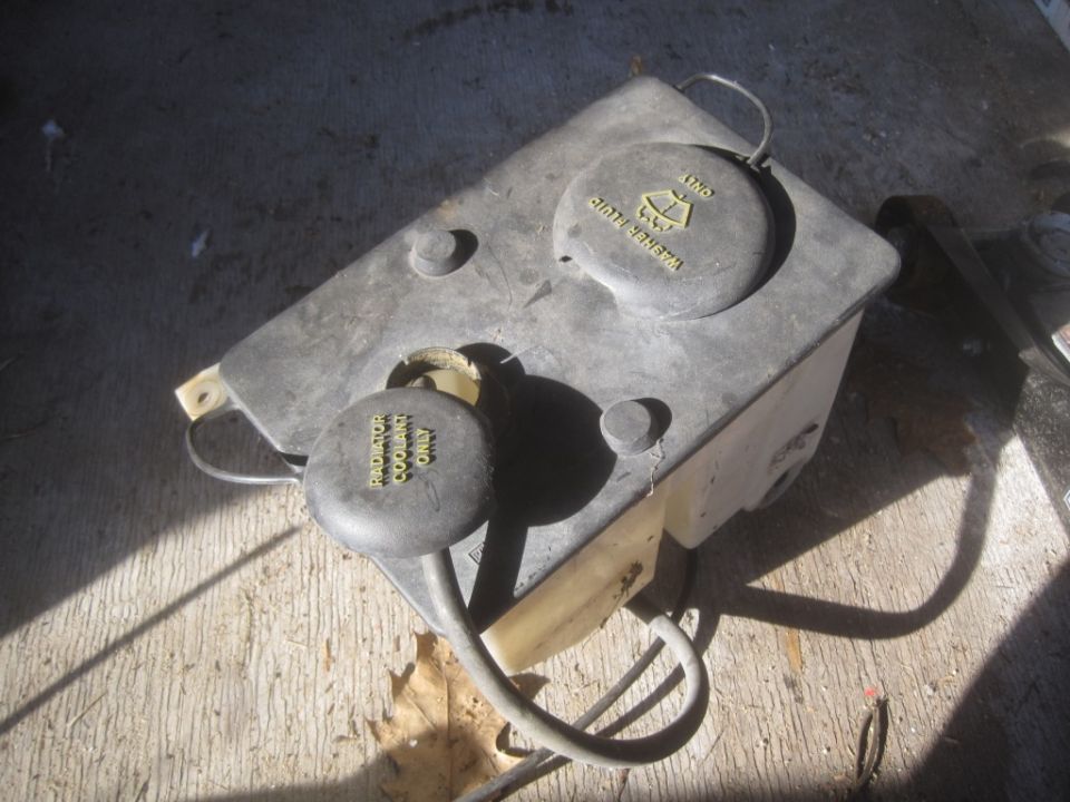 windshield washer fluid reservoir with caps labeled 'WASHER FLUID ONLY' and 'RADIATOR COOLANT ONLY'