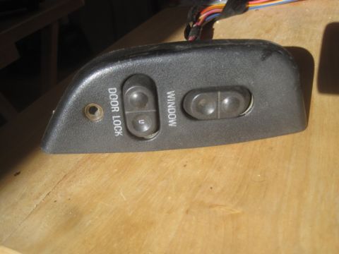 1993 Ford Bronco - This is a door lock and window switch assembly, likely for a vehicle's interior.
