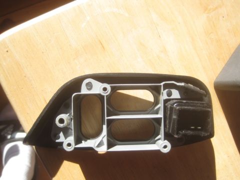 1993 Ford Bronco - Internal bracket and housing for a car part, possibly a headlight assembly, shown on a wooden surface.