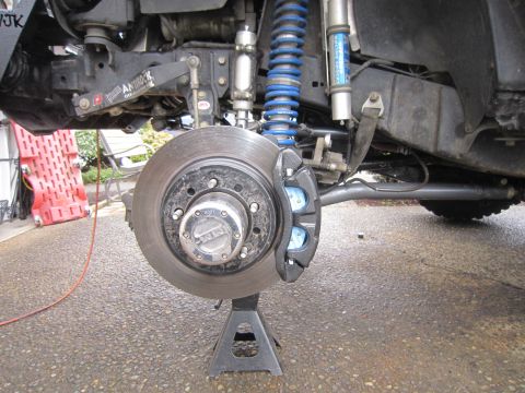 2008 Jeep Wrangler - This photo shows the front brake assembly of a vehicle, including the rotor, caliper, and suspension components.