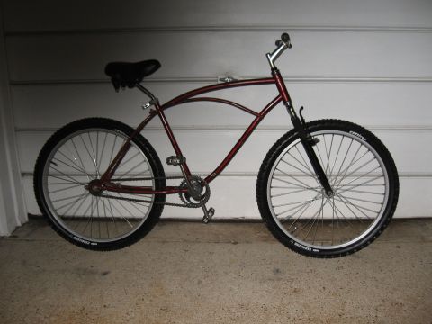 1994 Ford Bronco - A maroon bicycle with a unique frame design is parked in front of a garage door.