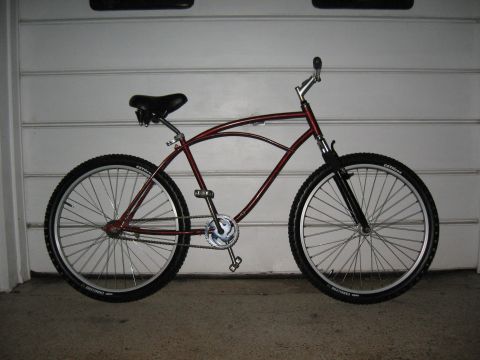 1994 Ford Bronco - This red cruiser bicycle features a distinctive frame design and is shown in a side profile against a garage door.