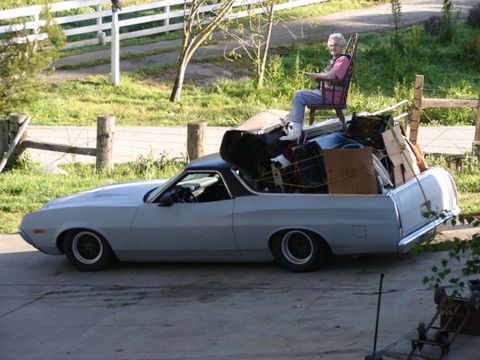 1971 Ford Ranchero - A 1971 Ford Ranchero is seen from the side, heavily loaded with various items and a person seated in a chair atop the cargo.