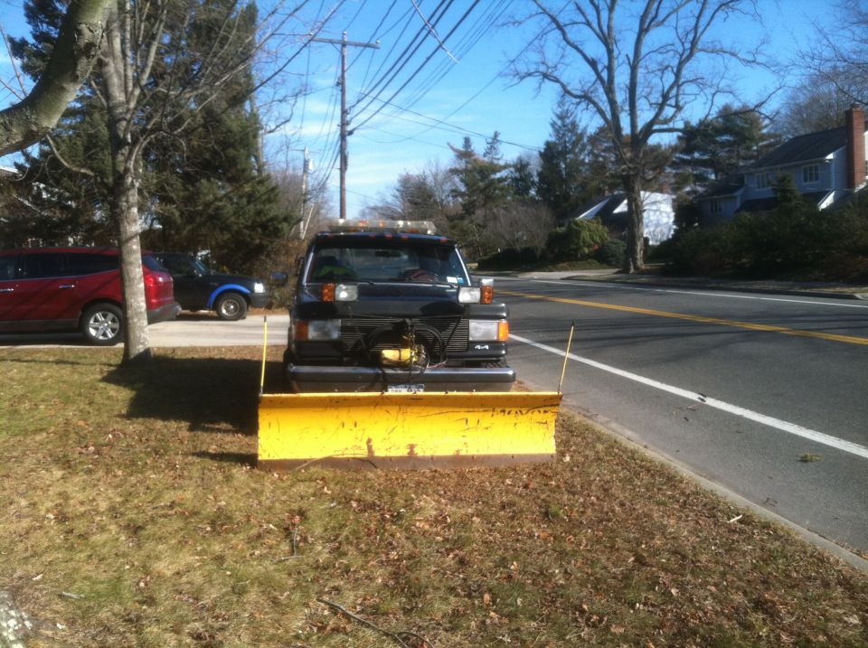 Black truck with yellow snow plow and 4x4 badge