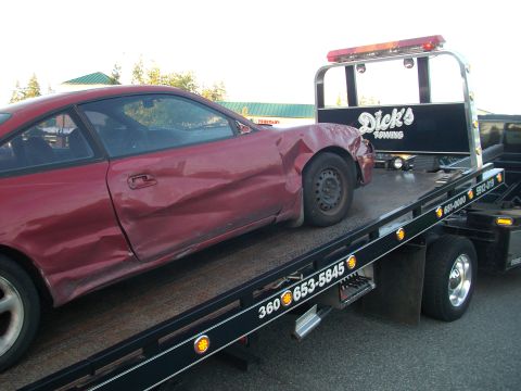 1989 Ford Probe - A red 1989 Ford Probe is loaded onto a tow truck after sustaining damage.