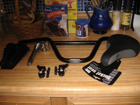 1994 Ford Bronco - Various bicycle parts laid out on a kitchen counter, including handlebars, a seat, and grips.