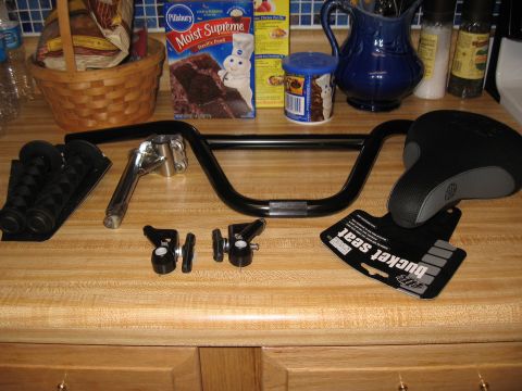 1994 Ford Bronco - A collection of bicycle parts, including handlebars, a seat, and grips, are laid out on a kitchen counter.