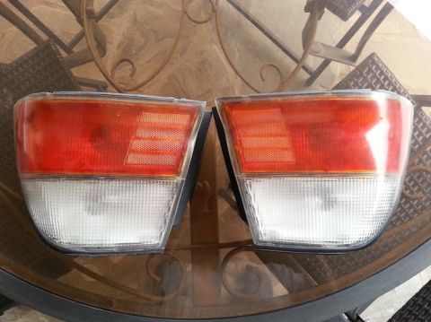 1978 Ford Bronco - A pair of car tail lights are displayed on a table.