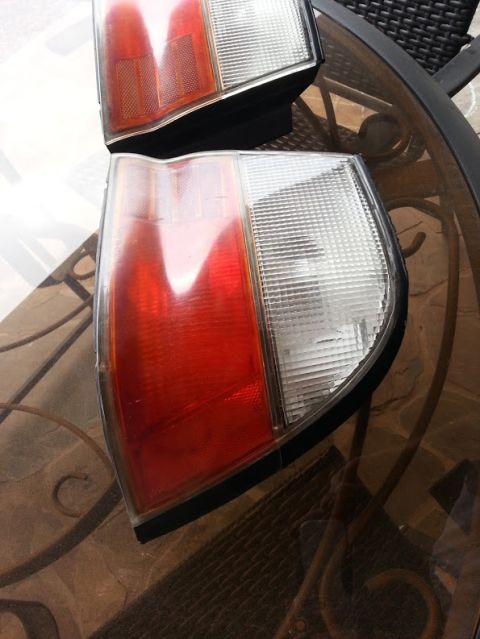 1978 Ford Bronco - A pair of vehicle tail lights are displayed on a table, likely for sale or repair.