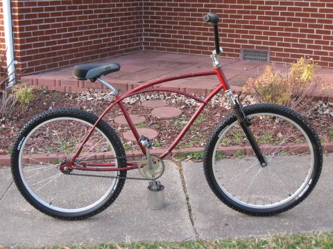 1994 Ford Bronco - A custom red bicycle with a unique frame design and knobby tires is parked on a sidewalk.