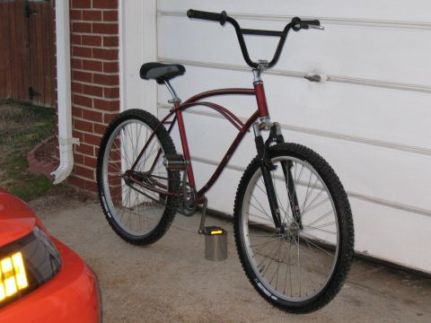 1994 Ford Bronco - A red bicycle with knobby tires and a curved frame is parked on a concrete surface.