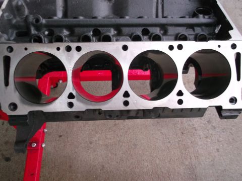 1965 Shelby Cobra - Engine block with cylinder bores, mounted on red engine stands.