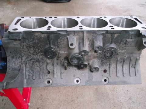 1965 Shelby Cobra - This is an engine block, not a 1965 Shelby Cobra. The block has four cylinder bores and is mounted on a red engine stand.