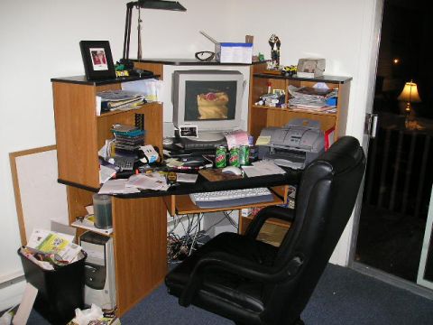 1994 Ford F-150 - A messy desk setup includes a computer, printer, and office chair, with a view of a balcony at night.