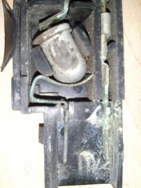 1994 Ford Bronco - This is a close-up view of a corroded automotive light socket with visible wiring and electrical contacts.