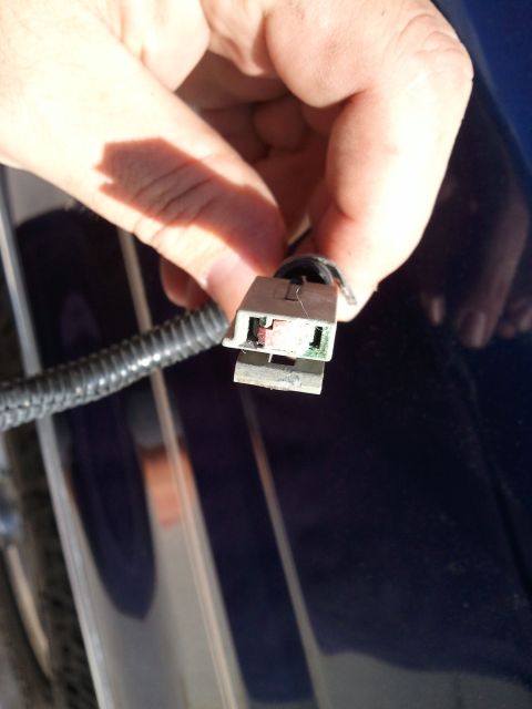 1994 Ford Bronco - Close-up of a hand holding an electrical connector with visible internal contacts.