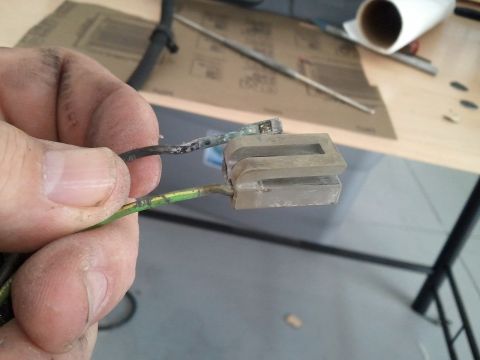 1994 Ford Bronco - A hand holds a corroded electrical connector with two wires, one green and one black, showing signs of wear.