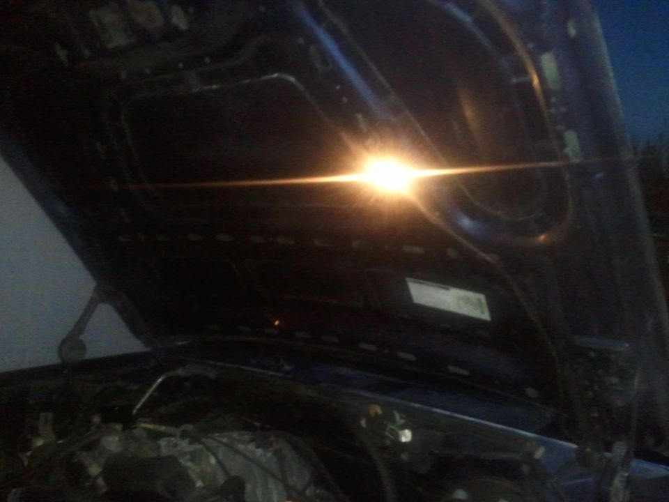 looking into engine bay with hood open, light shining bright