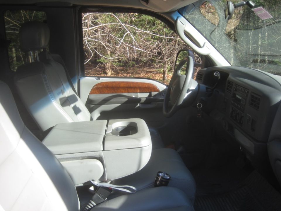 2003 Ford F-350 interior with gray leather seats, wood trim, and dashboard