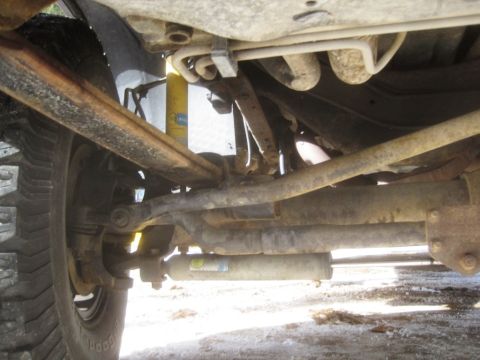2003 Ford F-350 - Close-up of truck undercarriage, focusing on suspension and exhaust system components.