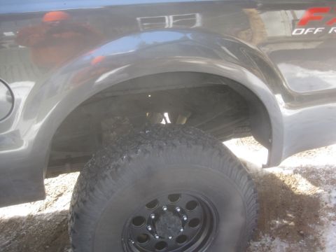 2003 Ford F-350 - Close-up of the rear wheel well and tire on a 2003 Ford F-350 pickup truck.