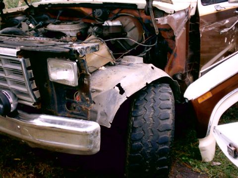 1980 Ford Bronco - Front corner of a 1980s Ford truck with the fender removed, exposing the rusted inner fender well, radiator support, wiring and air cleaner…