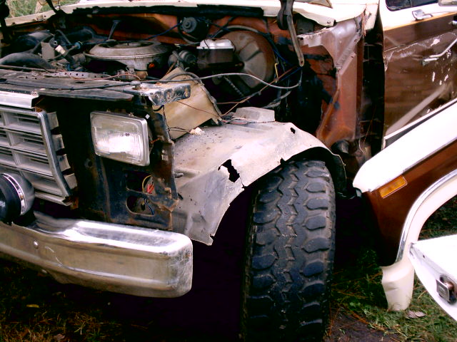 1980s Ford truck front end with fender removed showing rusty inner fender and headlight