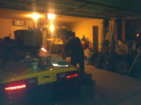 1995 Ford Probe - Garage scene with a yellow car's rear visible, a person is working in the background.