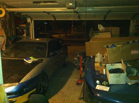 1995 Ford Probe - A 1995 Ford Probe is parked in a garage with another vehicle and storage boxes.