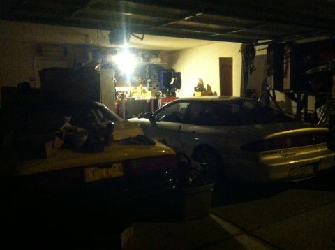 1995 Ford Probe - A white 1995 Ford Probe is parked in a cluttered garage.
