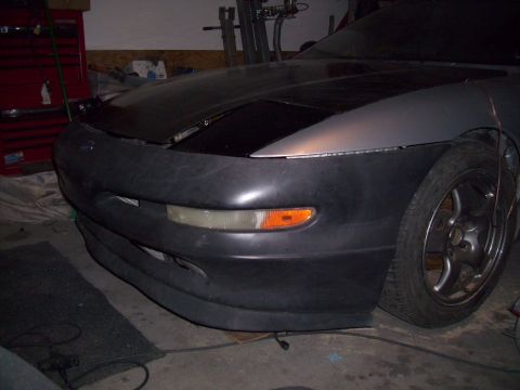 1995 Ford Probe - Front end of a 1995 Ford Probe undergoing repair or modification in a garage.
