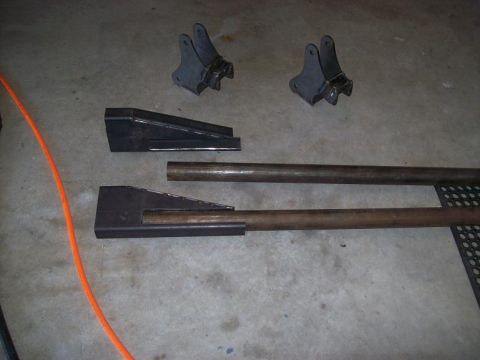 1988 Ford Bronco - Custom fabricated suspension components and steel tubing laid out on a concrete floor.