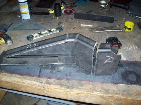1988 Ford Bronco - Fabricated metal components are shown on a cluttered workbench, ready for assembly or further modification.