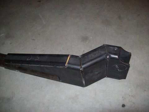 1988 Ford Bronco - A custom-fabricated metal component, possibly for a vehicle, rests on a concrete floor.