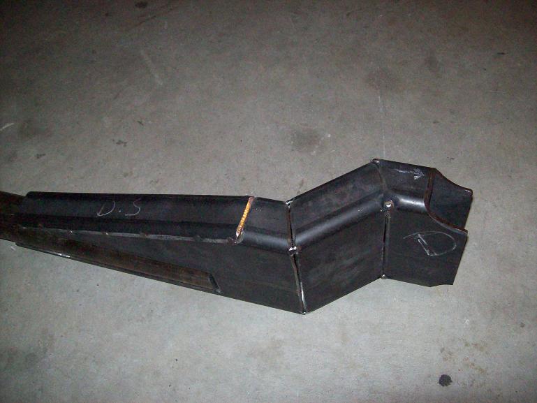 fabricated metal part with 'D.S.' and 'D' written on it