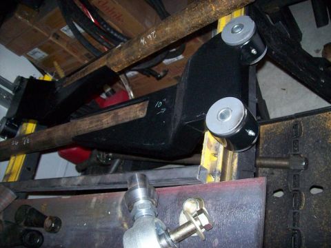 1988 Ford Bronco - Close-up of automotive suspension parts, including a black arm with gray bushings.