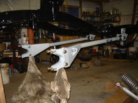 1988 Ford Bronco - Close-up of vehicle suspension components and frame in a workshop setting.