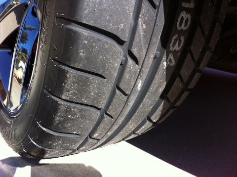 2010 Dodge Challenger - A close-up shot focuses on the tread pattern of a performance tire mounted on a shiny chrome wheel.