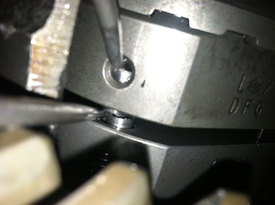 Close-up of a metal engine component with stamped letters 'DFC' and '127'