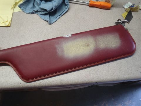 1979 Ford Bronco - A car sun visor is shown on a workbench with a rag and screwdriver nearby.