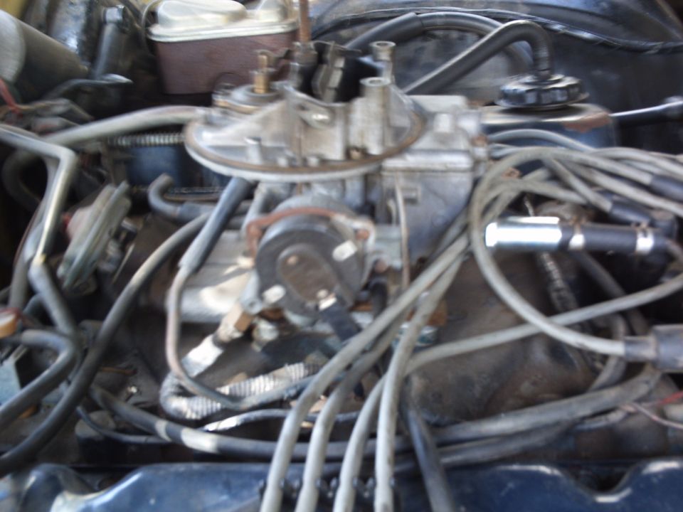 Close-up of a carburetor with many wires connected to it