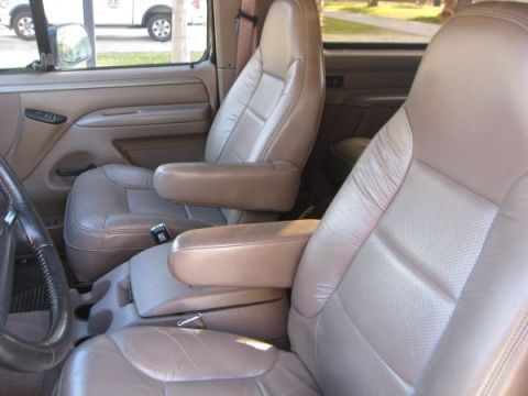 1995 Ford Bronco - Interior view of tan leather bucket seats and center console in a 1995 Ford Bronco.