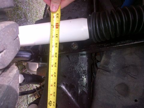 1994 Ford Bronco - Close-up view of a shock absorber and suspension parts, with a tape measure indicating length.