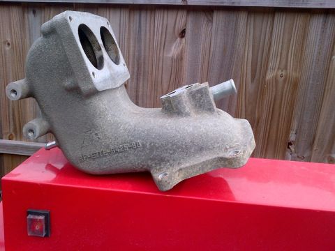 1994 Ford Bronco - Intake manifold with "F-ETTE 9425-88" casting number visible, resting on a red surface.